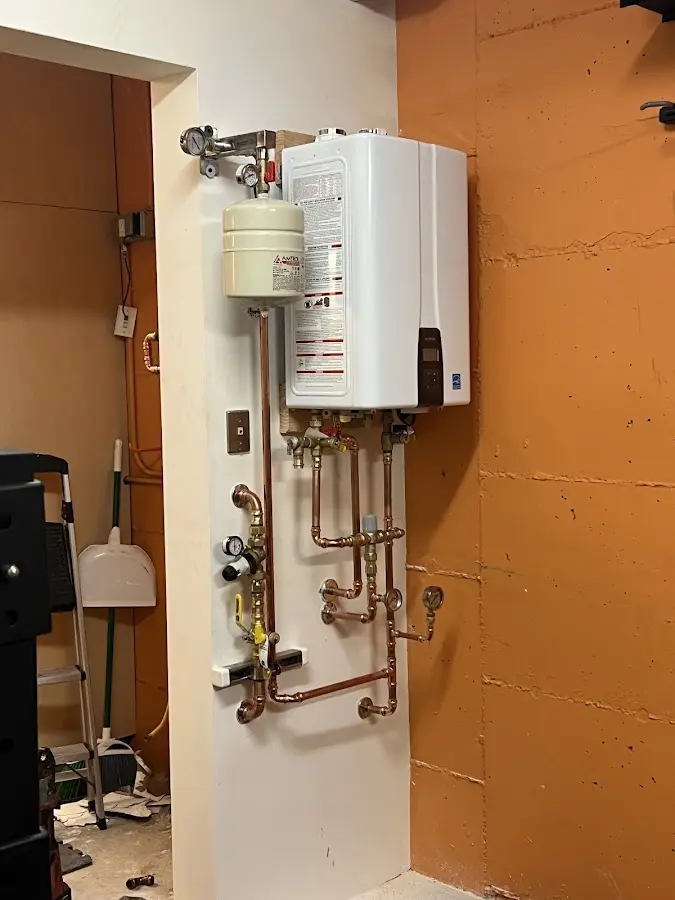 Plumbing technician inspecting water heater connections in Hillsborough